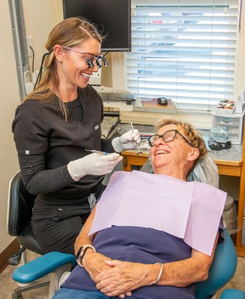 woman in dentist chair looking at x-ray