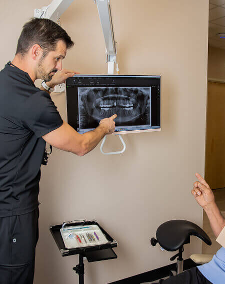 Dr. Pocock speaking with a patient while pointing at dental x-rays at Pocock Family Dental in Twin Falls ID.